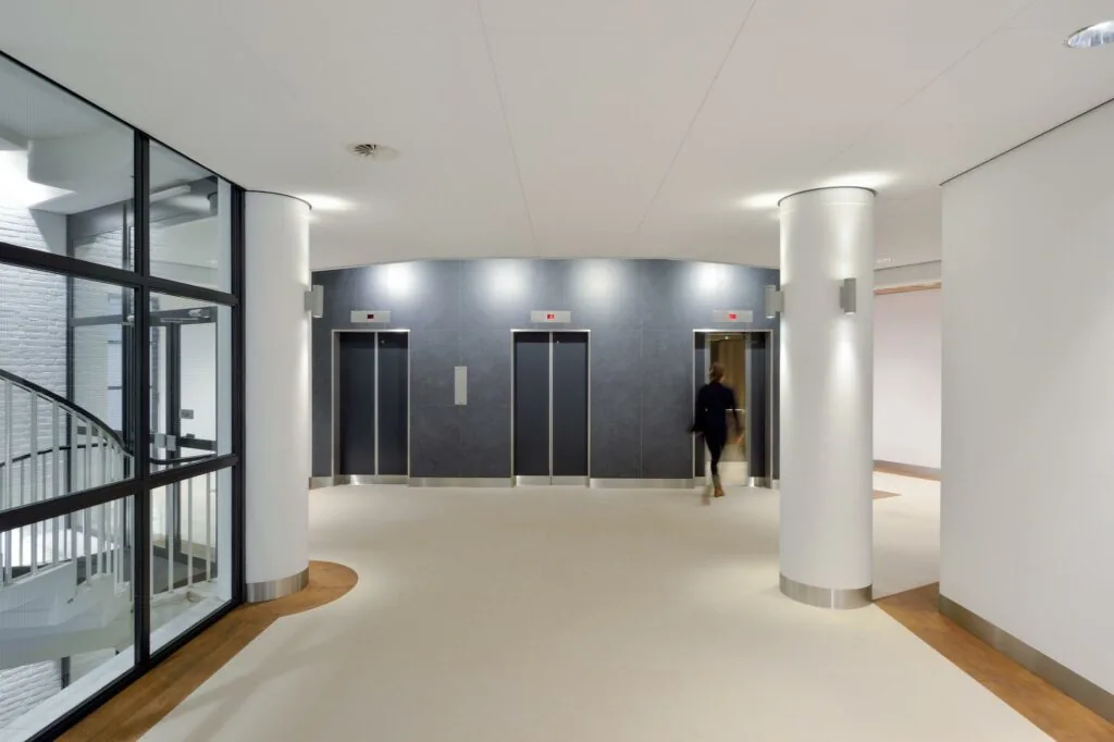 Moderne liftlobby met drie liften in een kantoorpand aan de Floris Grijpstraat.
